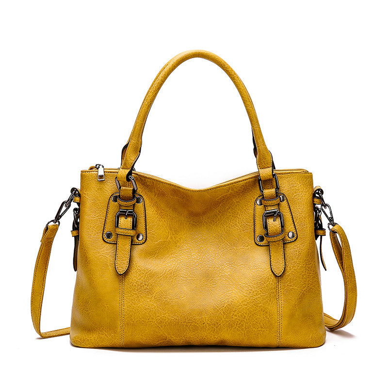 Yellow handbag with a strap on a white background