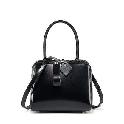 Black handbag with a strap on a white background