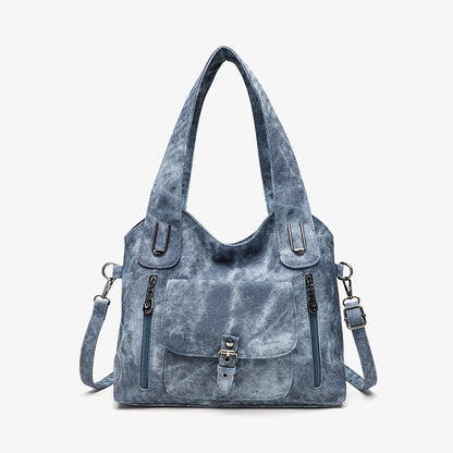 Blue tie-dye handbag with multiple pockets and straps on a white background