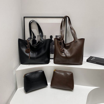 Black and brown handbags on a white shelf with a framed picture in the background.
