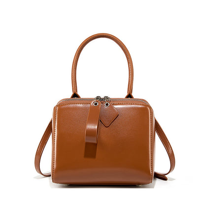 Brown leather handbag with a strap on a white background
