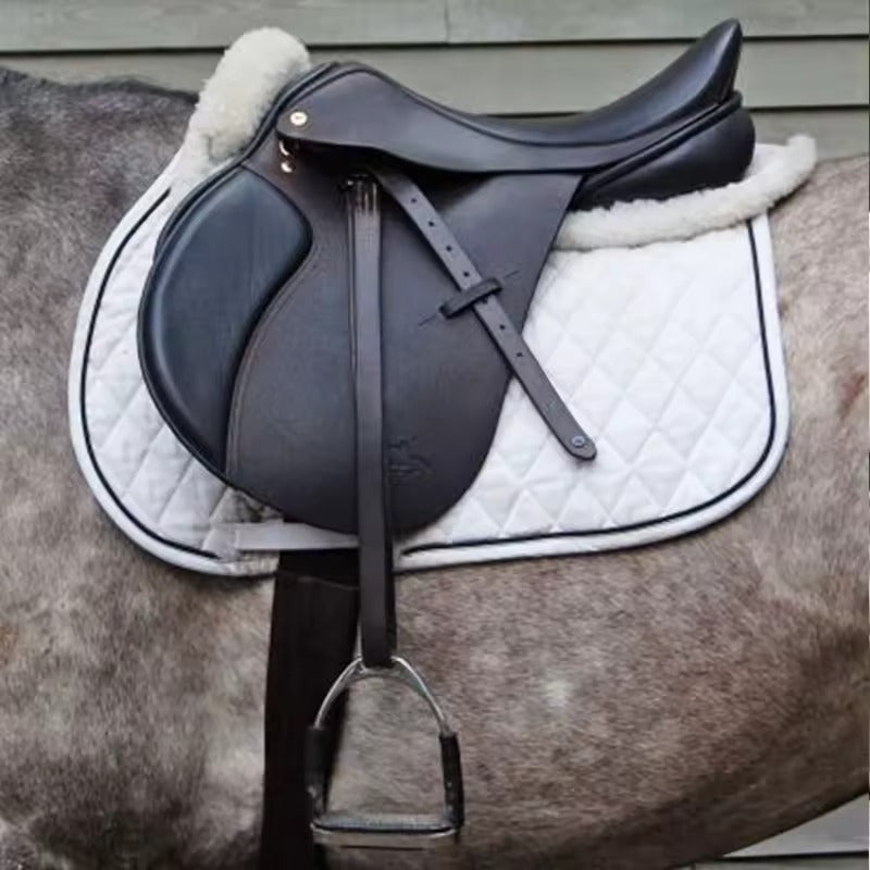 Brown leather saddle on a horse with a white quilted pad