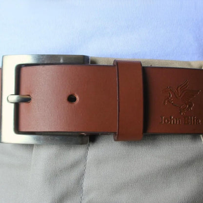 Brown leather belt with silver buckle on a light blue fabric background