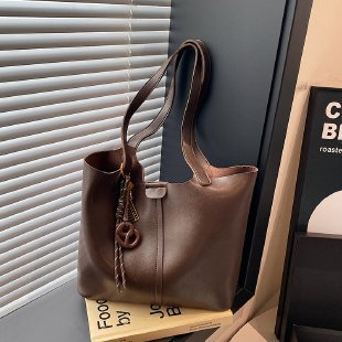 Brown leather handbag on a surface with a blurred background