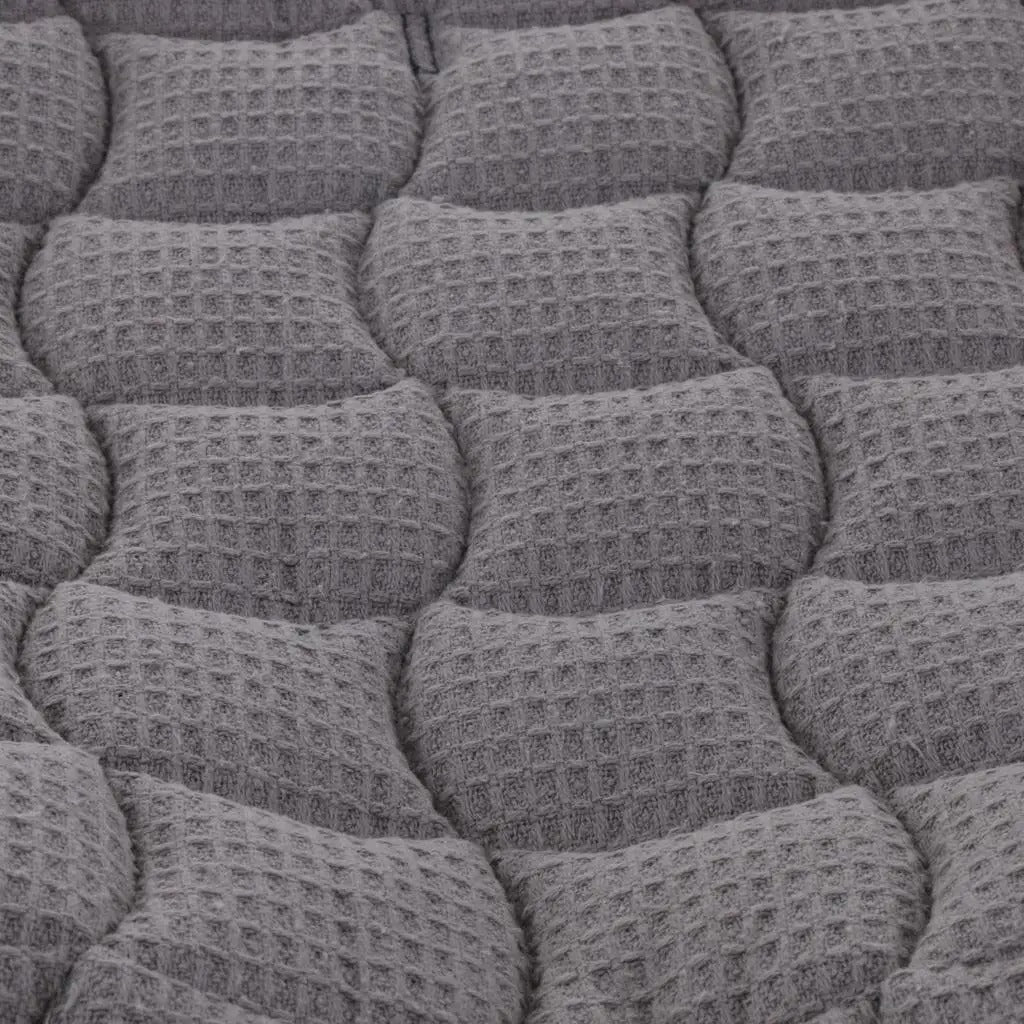 Close-up of a textured gray cushion with a waffle pattern
