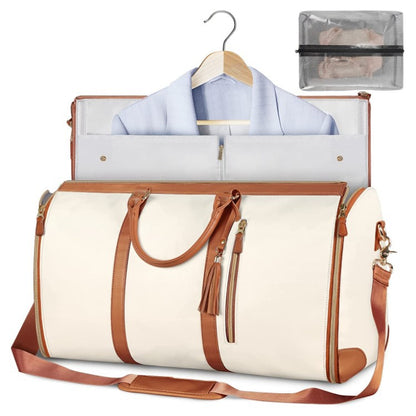 White travel bag with brown leather straps and trim, open to reveal a shirt on a hanger and a clear pouch.