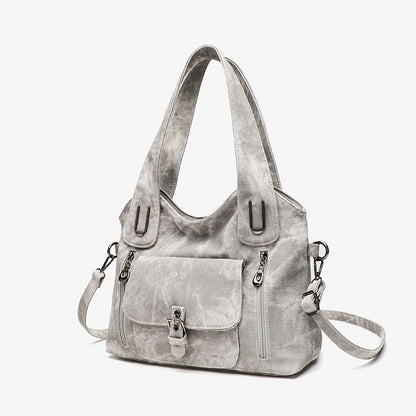 Gray handbag with multiple pockets and straps on a white background