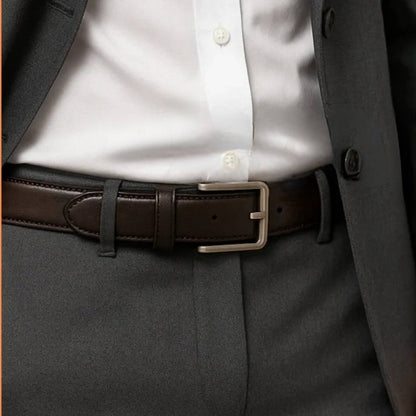Close-up of a person wearing a brown belt with a gray suit and white shirt.